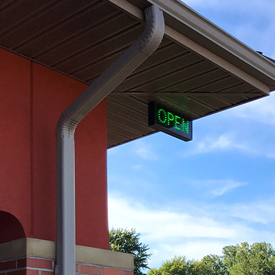 Open LED Sign hanging from roof eave.