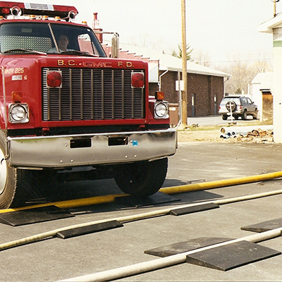 Hose ramp shown in use protecting hose from passing fire truck.